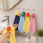A person drying hands with a yellow carrot-shaped towel, with three other colorful animal-shaped towels hanging on – view 8