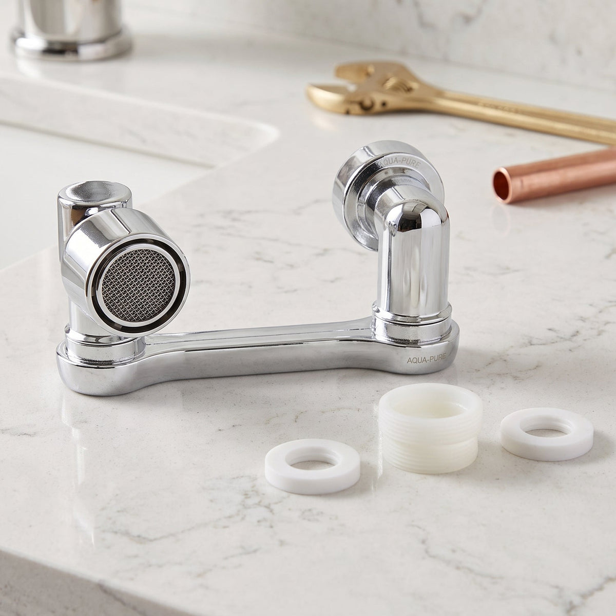 The chrome swivel faucet aerator with white plastic washers on a white marble countertop, with tools in the background.