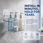 A chrome shower caddy with three bottles and a jar hangs from a clear adhesive hook on a gray tiled wall.