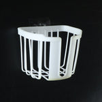 A white plastic toilet paper holder with vertical slats and a clear adhesive hook is shown against a dark background.