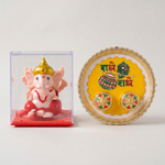 A gold-rimmed white and yellow pooja thali with Radhe Radhe text and two small containers sits on a light surface beside a