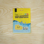 A yellow and blue package for "Latex Waterproof Shoe Cover" with a cartoon shoe graphic rests on a light wood surface.