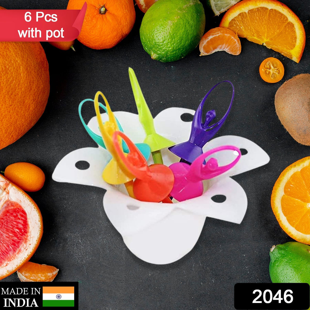 Six colorful dancing doll fruit forks in a white flower-shaped stand, surrounded by various fruits.