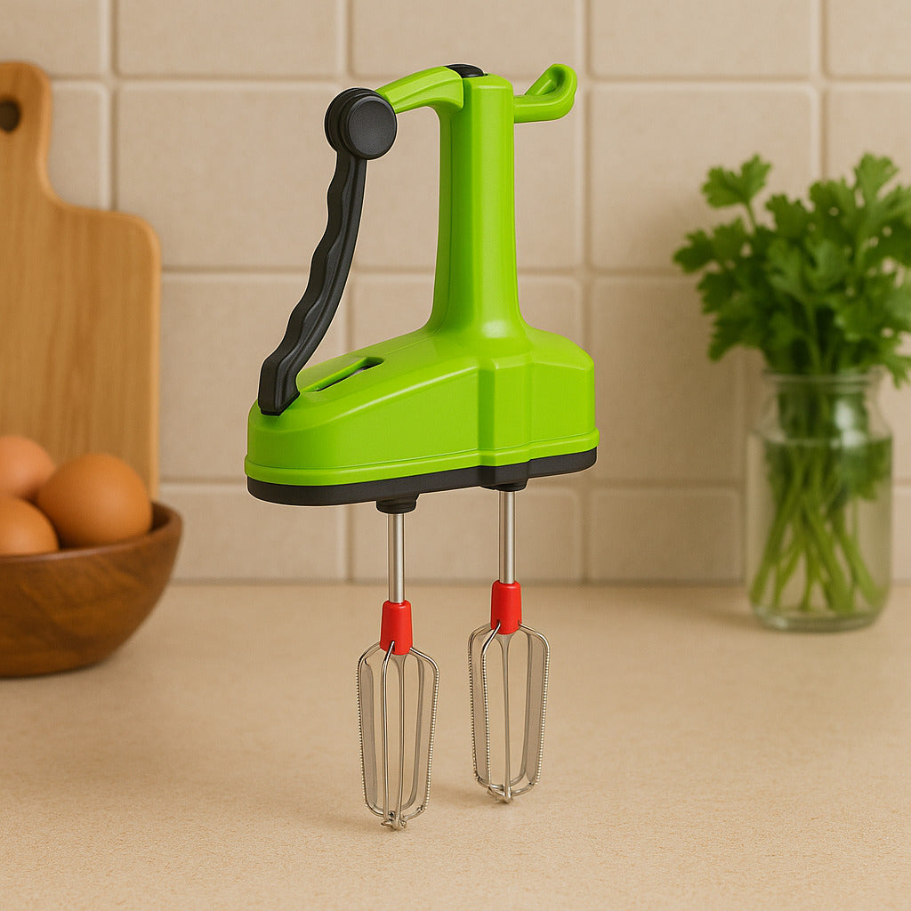 A green manual hand blender with black handle and red-tipped whisks sits on a kitchen counter with eggs and parsley in the