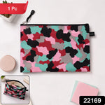 A flat, closed pouch with a pink, red, black, grey, and teal camouflage pattern, lying on a white surface next to a – view 2