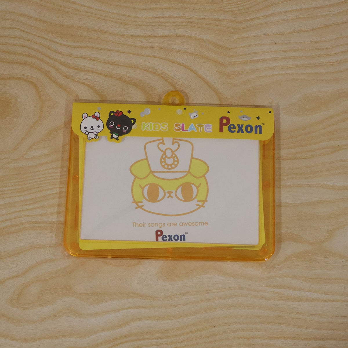 A yellow-framed Pexon writing board in clear plastic packaging, featuring a cartoon cat design on a wooden surface.