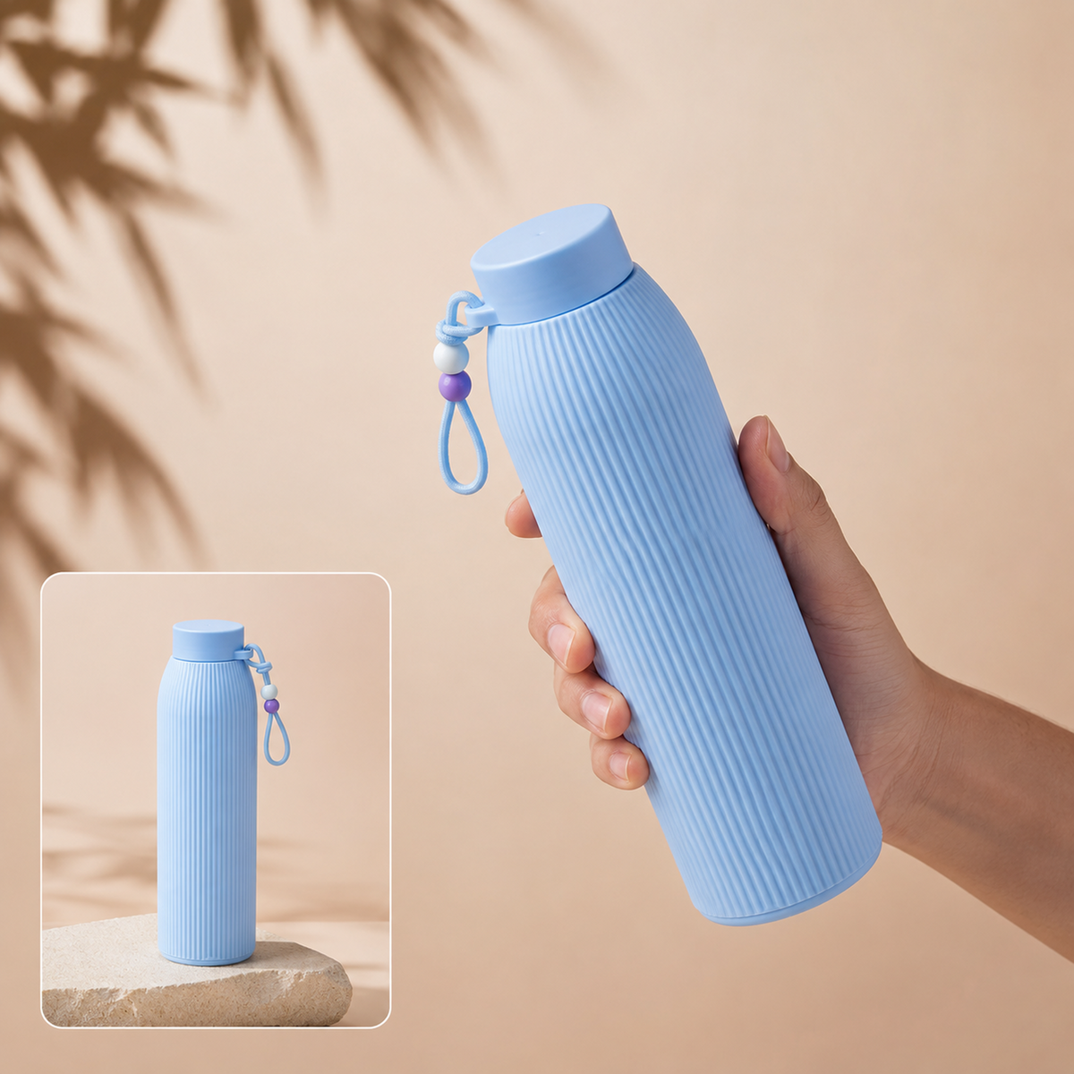 A hand holds a light blue ribbed glass water bottle with a beaded strap, with a smaller inset image showing it on a stone
