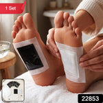 An overhead shot of various foot pad components, including black sachets and white adhesive sheets, on a marble surface.