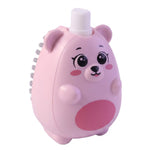 A pink bear-shaped soap dispensing brush with grey bristles on its side is shown on a white background.