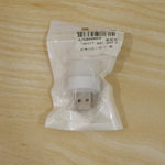 A white USB mini light bulb sealed in a clear plastic bag with a label, resting on a light wooden surface.