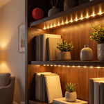 LED strip lights illuminate a dark wooden bookshelf with books and small potted plants.