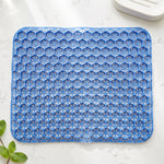 Close-up, top-down view of the blue honeycomb gel cushion on a white surface with a mint sprig.