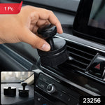 A hand holds a black detailing brush, cleaning a car's air vent, with a small inset showing the brush and its base – view 2