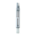 The white and gray multi-tool cleaning pen with all its components visible on a white background.