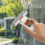 Two white and orange mini sponge mops; one rests on a white countertop, and the other is mounted vertically on a grey wall.
