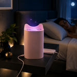 A pink cat-eared mosquito lamp glows purple on a nightstand next to a sleeping woman in a dark room.