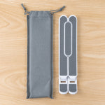 Folded white and gray laptop stand next to a gray drawstring carrying pouch on a wooden surface.