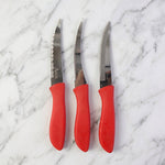Kitchen knife slicing a tomato