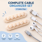 Two beige flower-shaped cable organizer clips and various cables (USB, Lightning, USB-C, earphones) on a light blue surface.