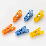 Durable non-slip plastic clips for laundry drying in bright colours.