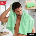 A man drying his hair with a light green microfiber towel in a bathroom, with a folded towel inset. – view 2