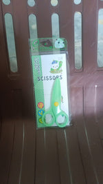 Plastic safety scissors cutting craft paper with rounded safety tips