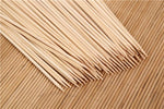Arrangement of natural wood bamboo skewers, highlighting their uniform 25 cm length.