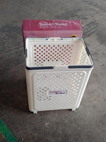 Foldable laundry basket being used to carry laundry with wheels
