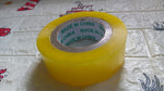 Transparent packing tape roll unwound slightly, showing its strong adhesive side.