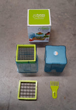 All components of the blue and green potato chipper laid out on a gray surface, with its retail box.