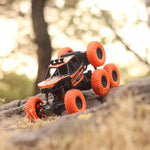 The 8-wheel Rock Climber remote control toy car driving across a rough, uneven surface.