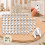 A hundred white plastic child safety socket covers on a wooden surface, with an inset showing one being inserted into an