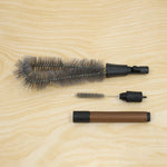 The three components of the cleaning brush set are displayed disassembled on a light wooden surface.