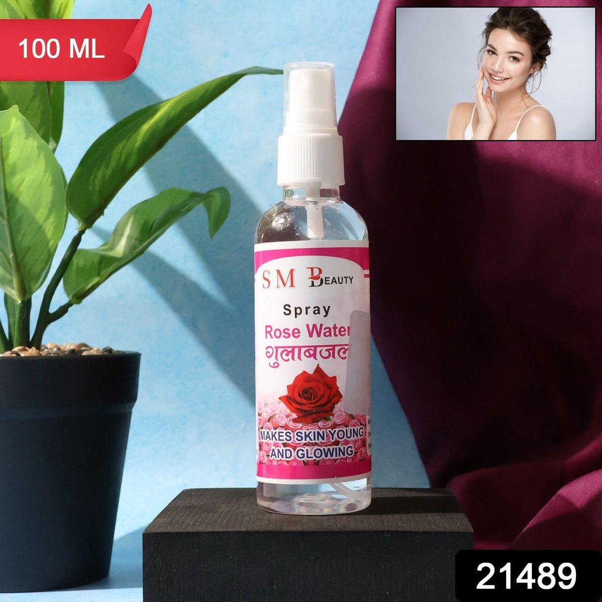 A clear bottle of SM Beauty rose water spray on a black block with a small inset image of a smiling woman.