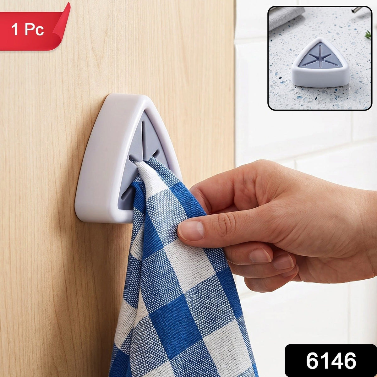 A hand inserts a blue and white checkered towel into a white and grey triangular wall-mounted towel holder onlight wooden