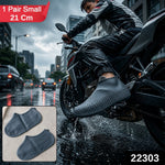 A person on a motorcycle in the rain wears a dark gray silicone shoe cover, with an inset showing a pair of the covers.