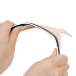 Two hands gently bend the flexible beige car mirror wiper, highlighting its pliable material.