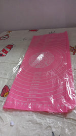 Hands rolling dough on the silicone baking mat, utilizing its non-stick property and guides.