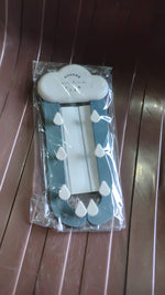 The cloud-shaped holder with blue rain-like arms and white raindrop hooks, packaged in clear plastic on a brown ribbed