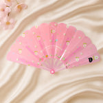 Floral hand fan resting elegantly on a table