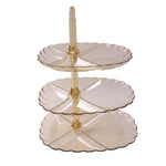 A translucent amber three-tier stand with empty scalloped plates is shown against a plain white background.