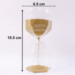 Smooth yellow sand flowing inside an elegant glass hourglass timer.