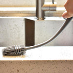A bottle cleaning brush with a long handle, ideal for reaching the bottom of tall containers.