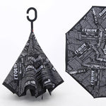 A reverse umbrella with a black and white newspaper print, shown both closed and partially open.