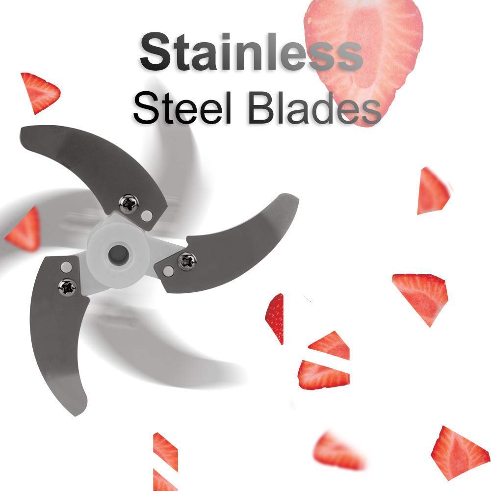 Three sharp, gray stainless steel blades rotate rapidly, surrounded by scattered red strawberry pieces on a white background.