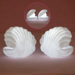 A child's hand reaching for the gentle glow of the Pearl Shell Night Lamp.