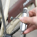 The silver 5-in-1 multi-tool is displayed with its knife, bottle opener, corkscrew, and awl extended.
