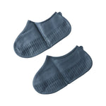Two dark grey silicone shoe covers are displayed side by side on a white background, showing their textured soles.
