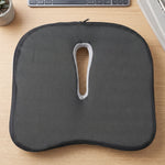 Bottom view of the dark grey, anti-slip ergonomic seat cushion with a central cutout and zipper.