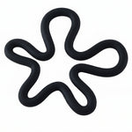 A black silicone flower-shaped hot pot holder on a plain white background, viewed from directly above.